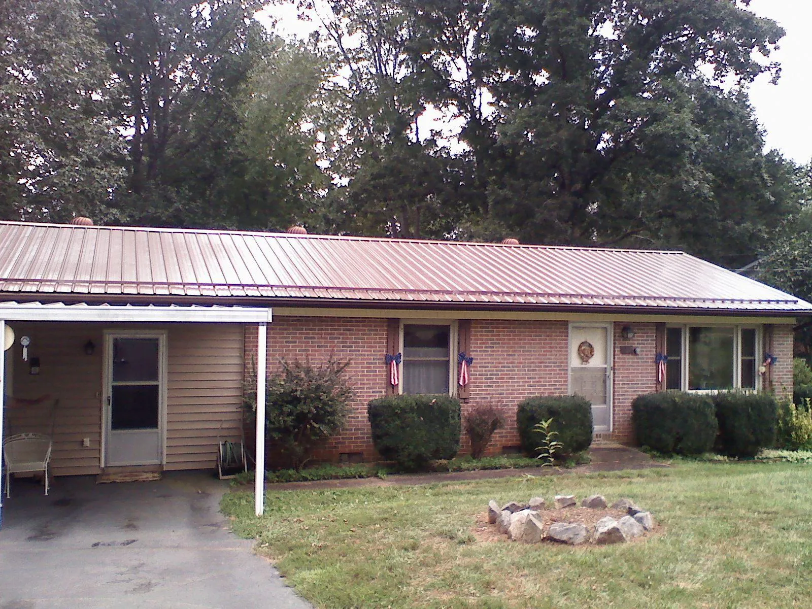 Bronze metal roof and carport on a brick ranch home — Roof Repair work by our crew in Chickamauga